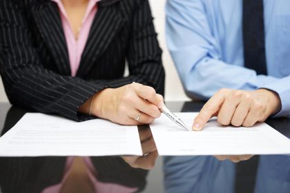 businessman and businesswoman are pointing to .article of the tr